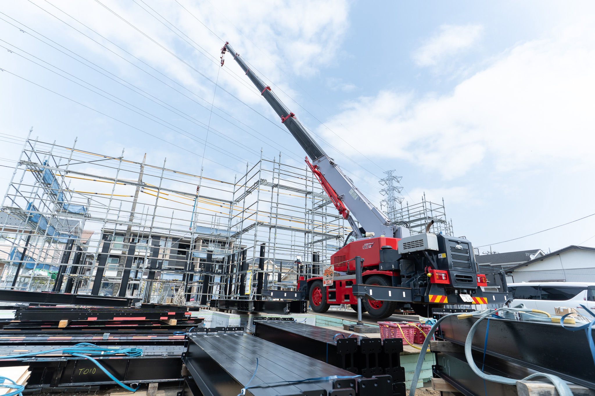 クレーン車と足場が組まれた新築工事現場の様子