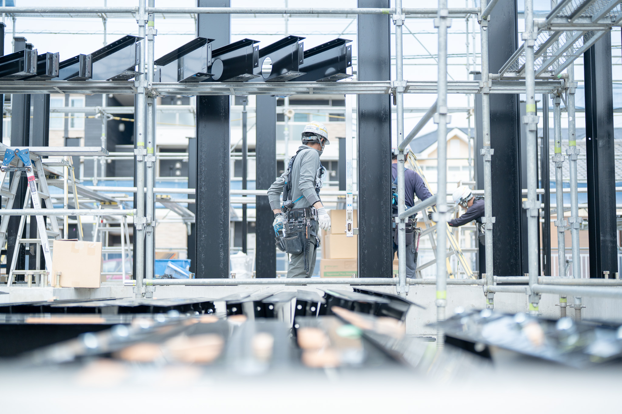 足場の中で建方作業を進める職人たちの様子