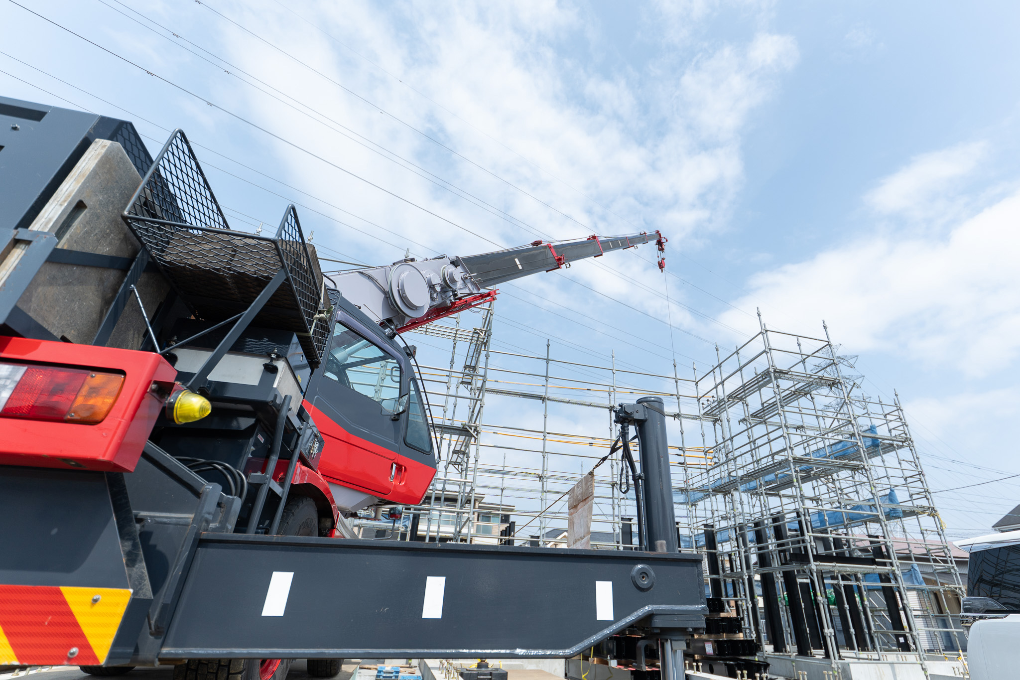 クレーン車が稼働する新築工事現場の様子